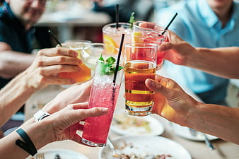 Friends toasting with colorful cocktails at a restaurant