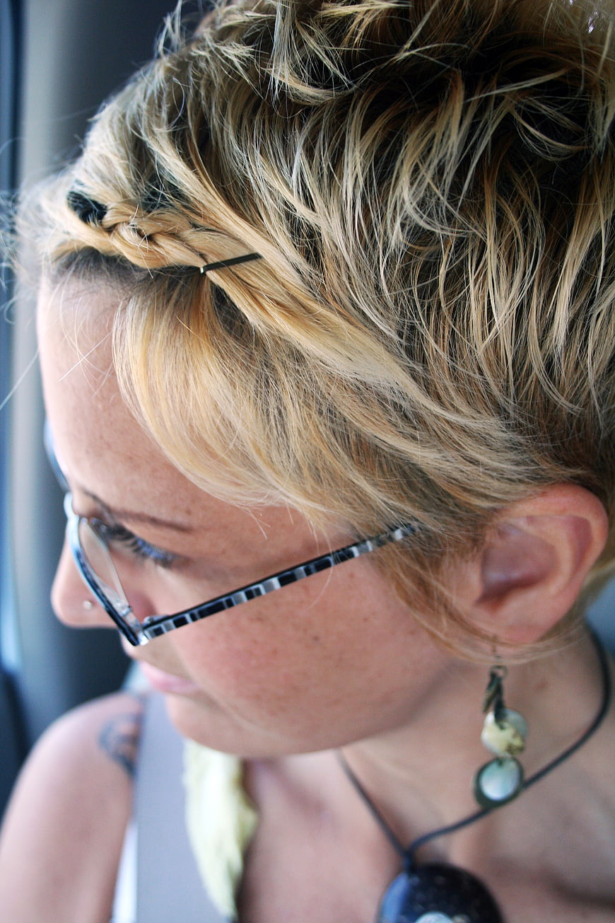 Close-up profile of blonde woman with braided updo and glasses