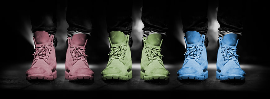 Colorful boots in pink, green, and blue on black background