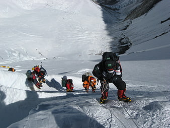 Mountain climbers ascending snowy glacier slope