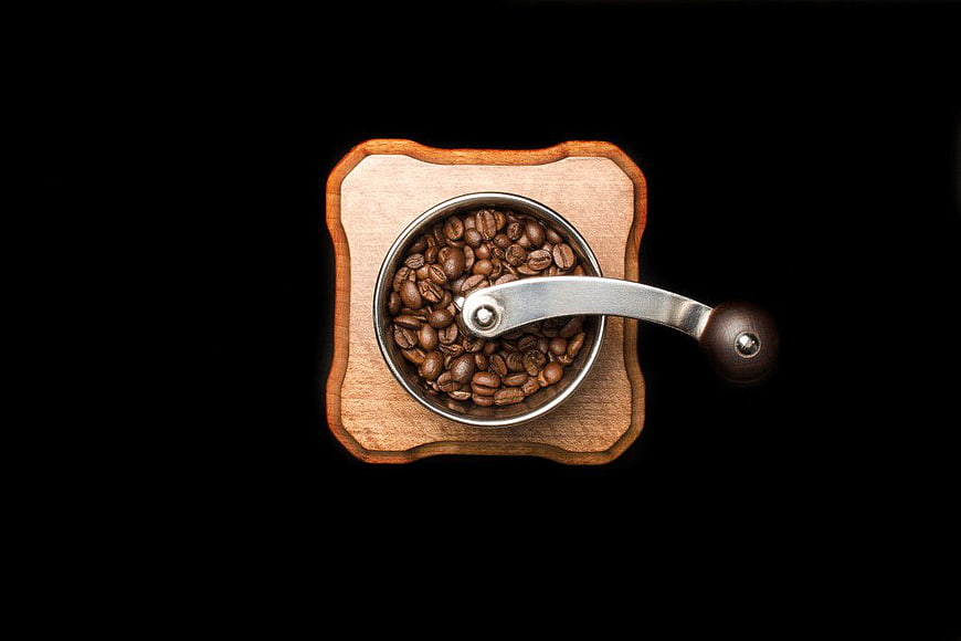 Overhead View of Wooden Coffee Grinder with Beans on Black