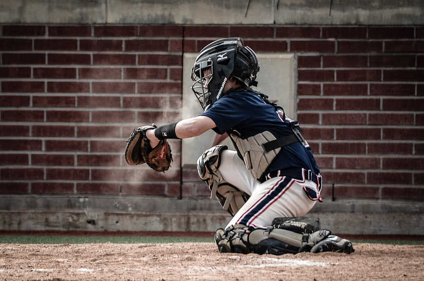 Youth Baseball Catcher in Action on Dirt Field