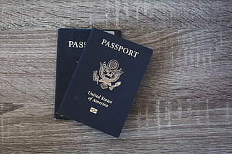 Two US Passports on Wooden Table