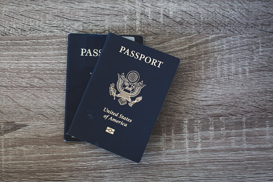 Two US Passports on Wooden Table