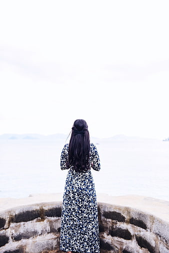 Woman in Floral Dress Looking Out at the Ocean