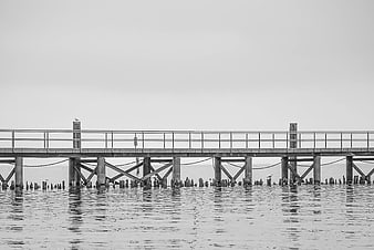 Black and white wooden pier extending over calm water