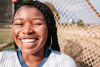 Close-up portrait of smiling black woman outdoors