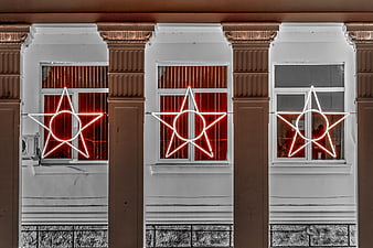 Red Neon Stars in Windows of Classic Building at Night