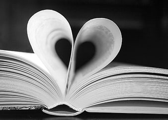Open book pages folded into a heart shape in black and white