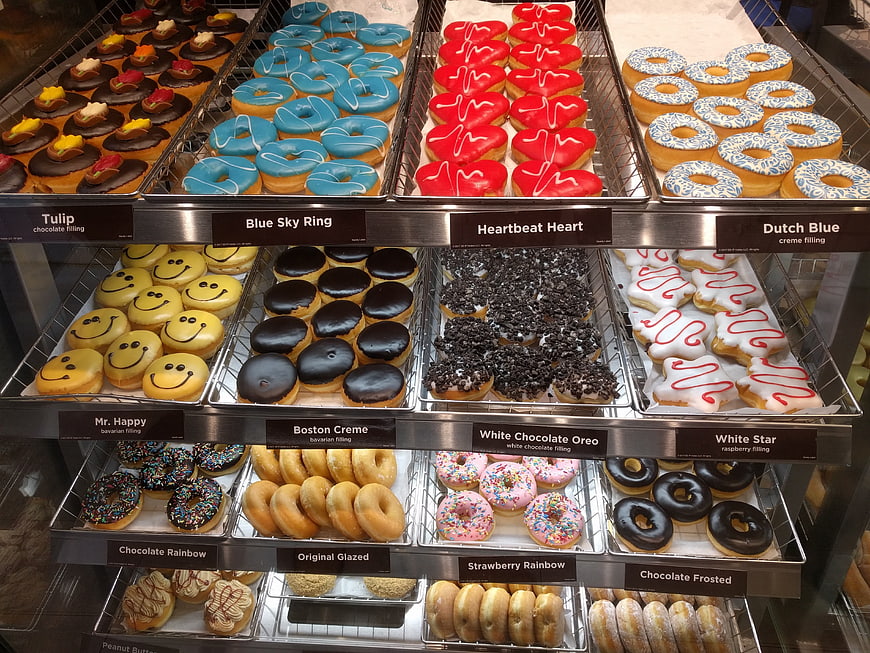 Colorful Donut Display Case With Variety Of Flavors And Glazes