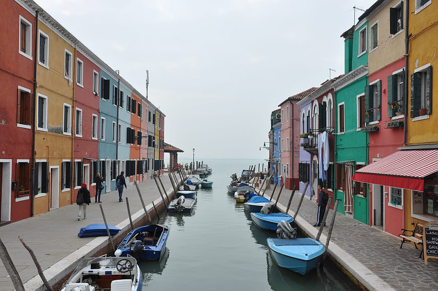Colorful houses and boats along a canal in Burano, Venice