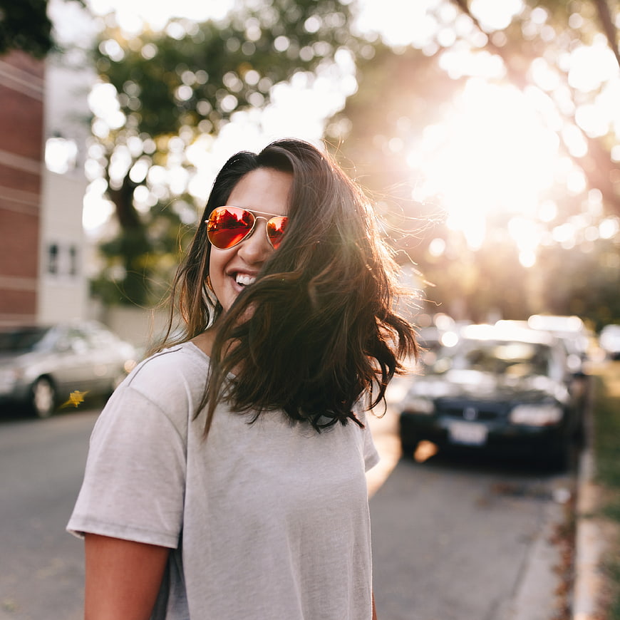 Happy Woman Wearing Sunglasses on a Sunny Street