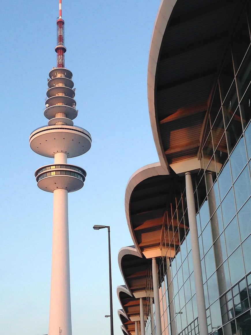 Low Angle View of White TV Tower and Modern Glass Building