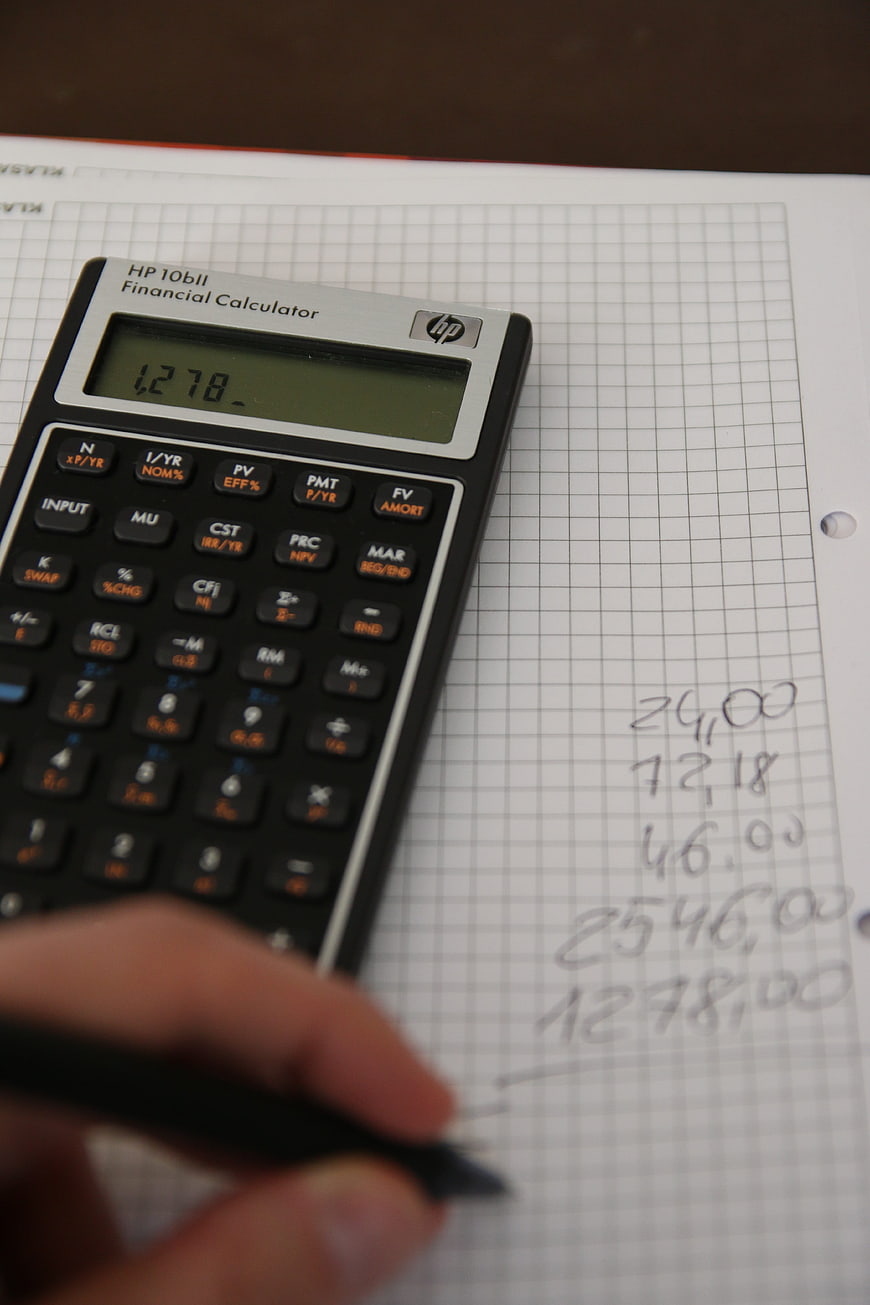 Financial calculator on graph paper with handwritten calculations