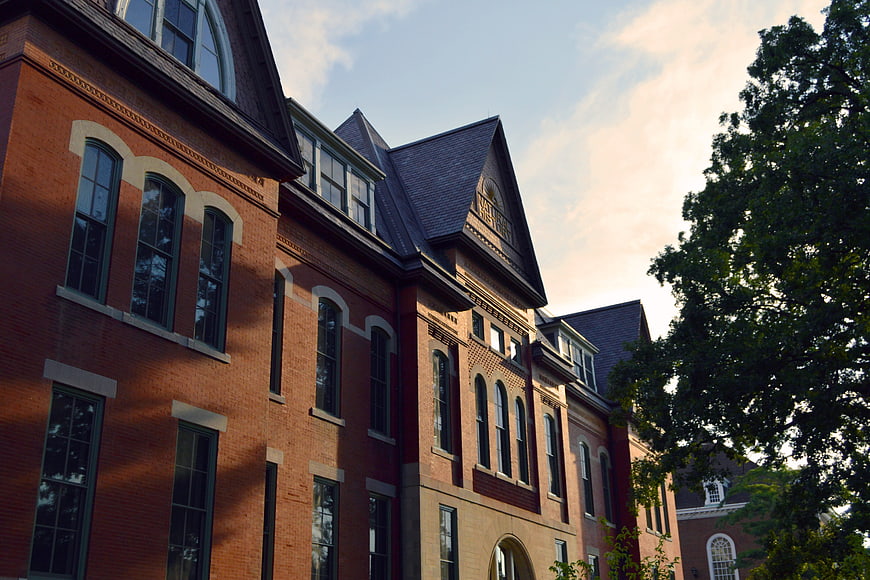 Historic Red Brick University Building Exterior With Arched Windows
