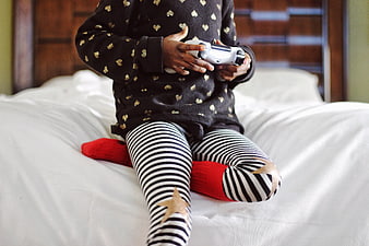 Child playing video games on bed with controller