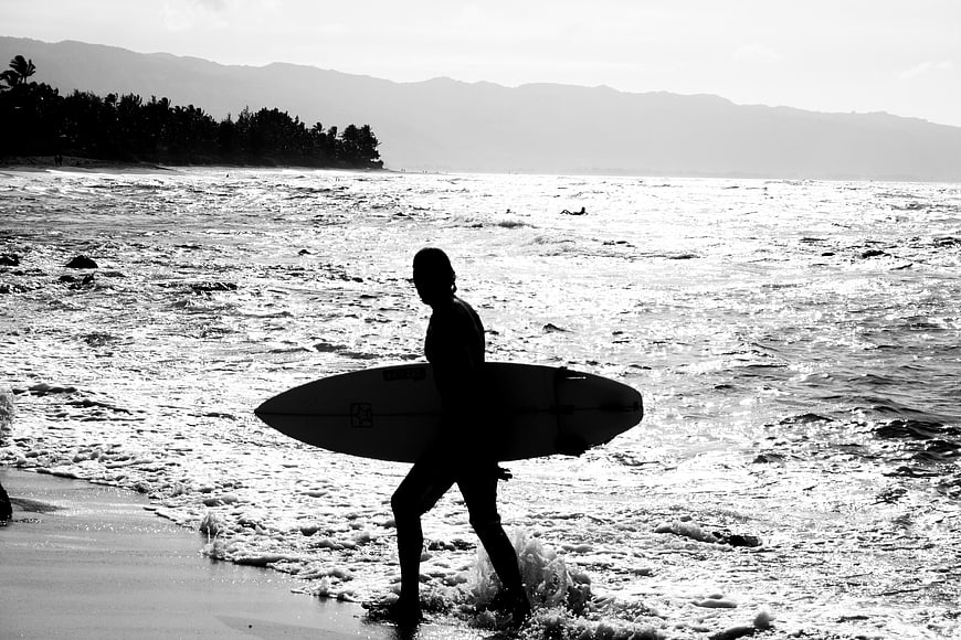 Silhouette of Surfer Walking into Ocean with Surfboard