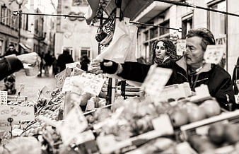 Black and white street market scene with vendor and produce