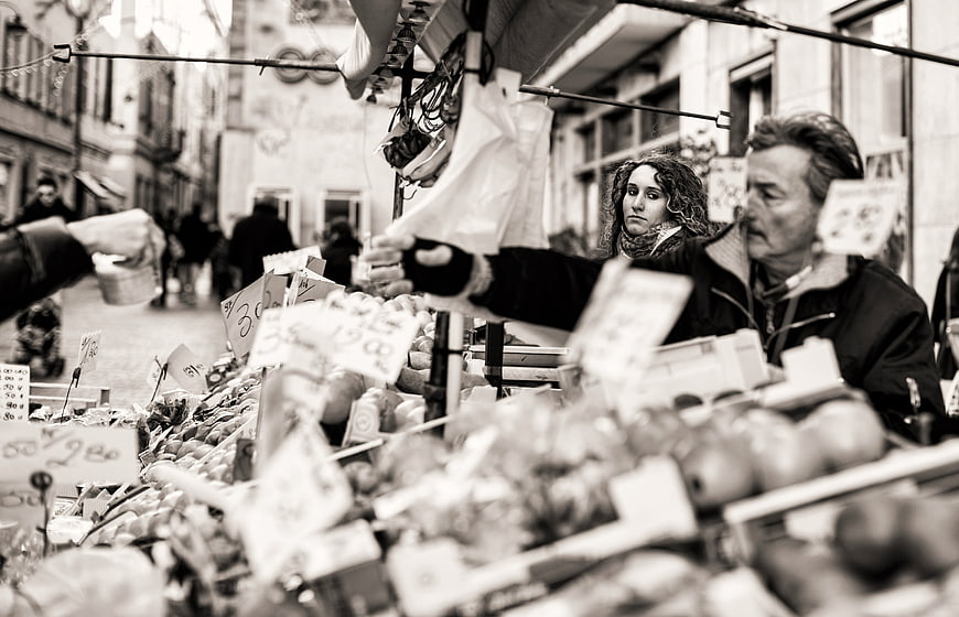 Black and white street market scene with vendor and produce