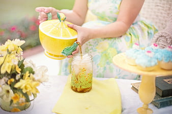 Woman Pouring Tea from Lemon Shaped Teapot at Garden Party