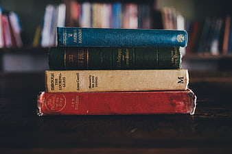 Stack of vintage classic literature books on wooden table