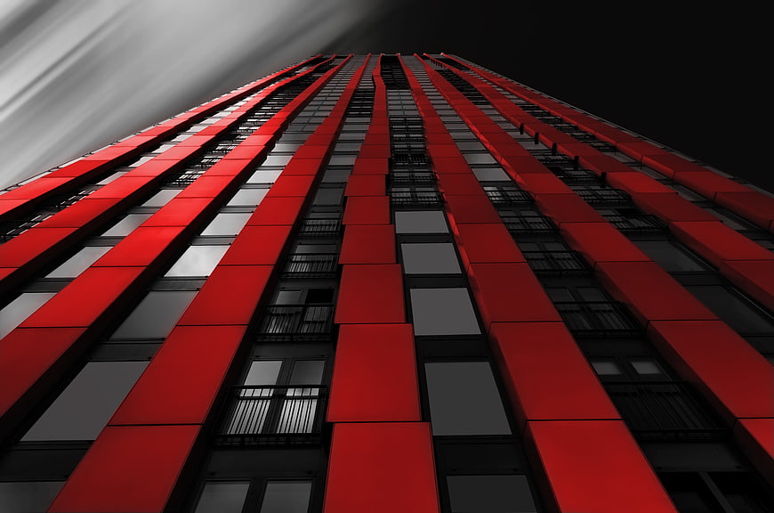 Low angle view of red and black modern skyscraper facade