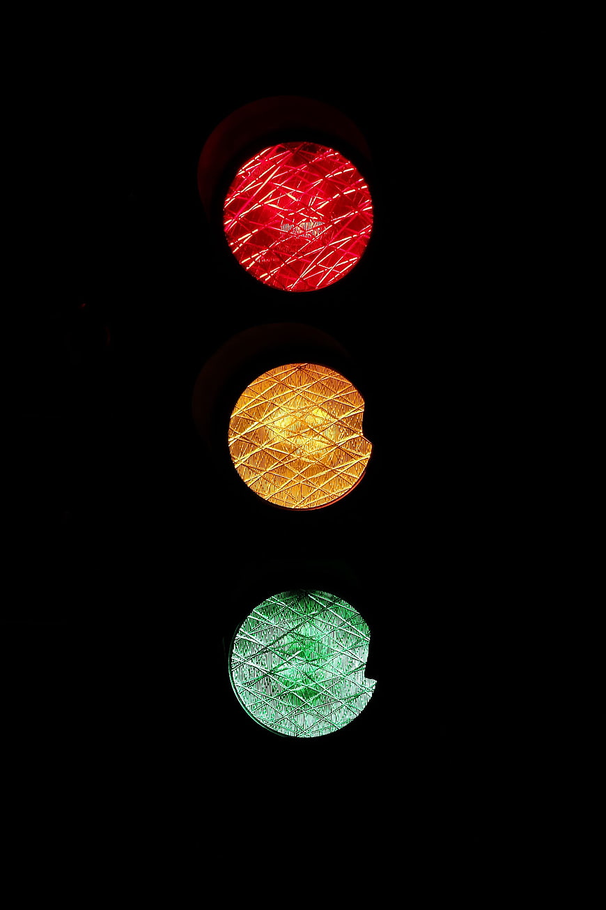 Close-up of illuminated red, yellow, and green traffic lights