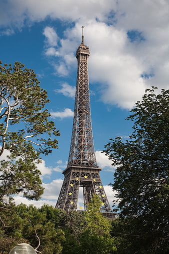 Eiffel Tower in Paris framed by trees against blue sky