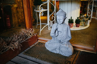 Serene Buddha Statue on Wooden Deck Outside Glass Door