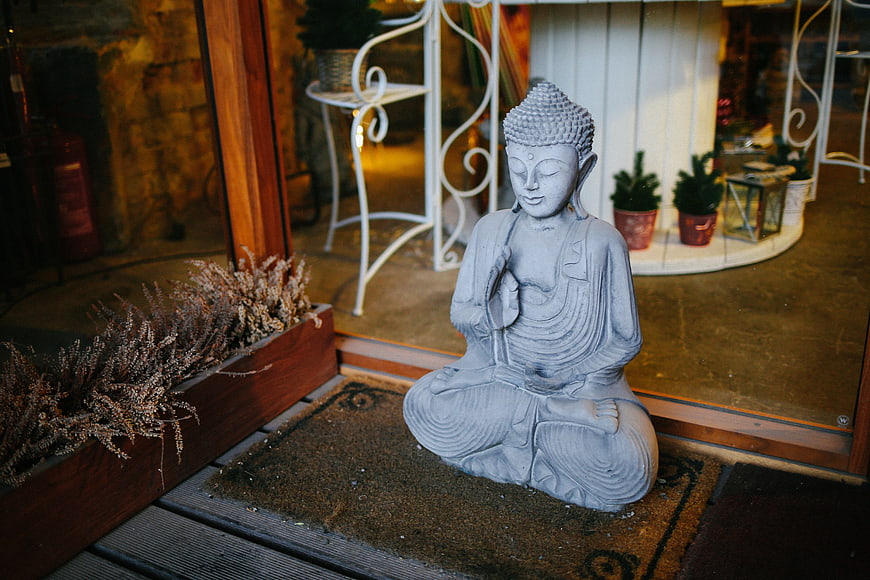 Serene Buddha Statue on Wooden Deck Outside Glass Door
