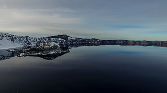 Serene Winter Landscape with Snowy Cliffs and Calm Lake