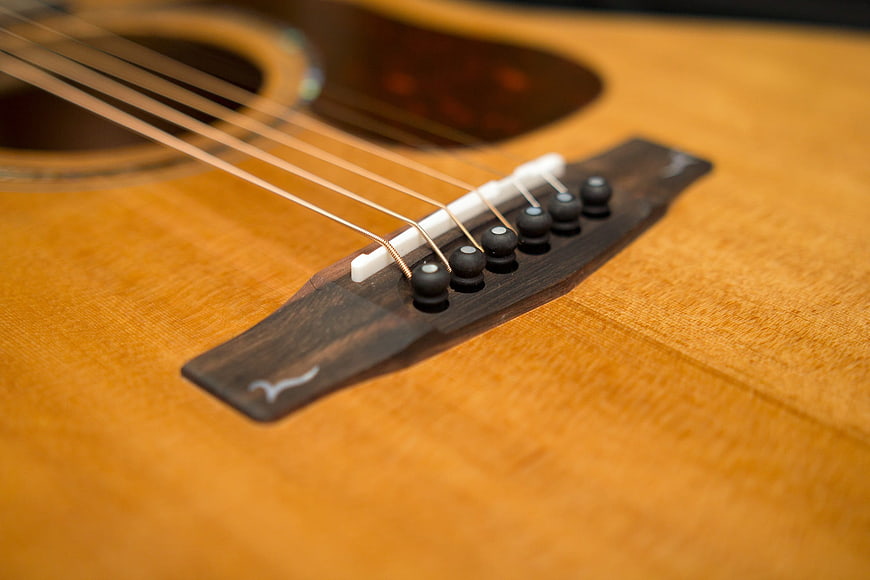Close-up of acoustic guitar bridge and strings