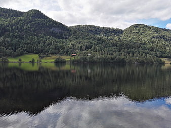 Serene Norwegian Lake with Forested Mountains and Reflections