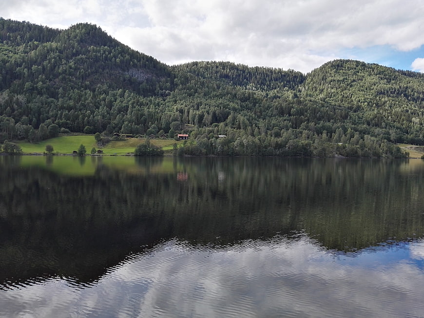 Serene Norwegian Lake with Forested Mountains and Reflections