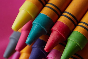 Close-up of colorful crayons on pink background
