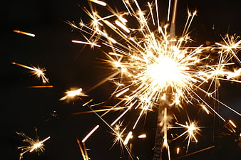 Bright Sparkler Fireworks Bursting Against Black Night Sky