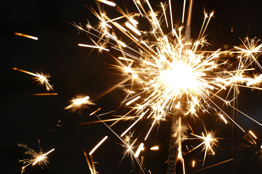 Bright Sparkler Fireworks Bursting Against Black Night Sky