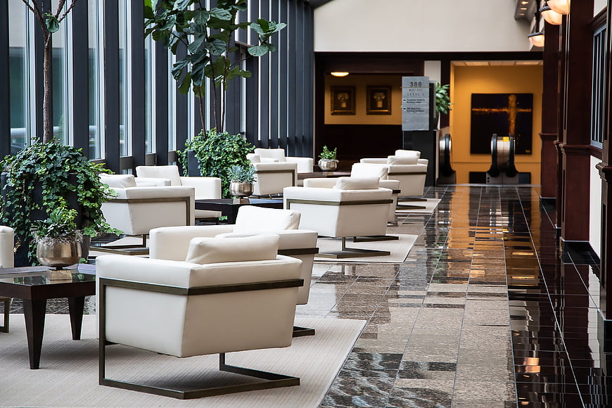 Modern Hotel Lobby Interior With White Armchairs And Polished Marble Floor