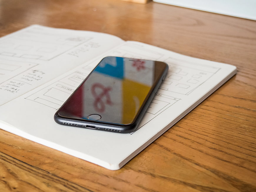 Smartphone on Notebook with Wireframe Sketches