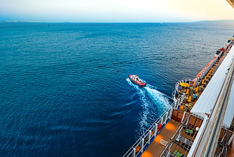 High Angle View of Small Boat Sailing Beside Cruise Ship Deck