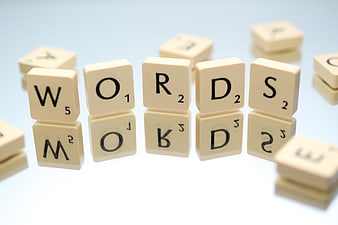 Scrabble Tiles Spelling Words on White Background