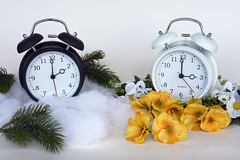Two alarm clocks with winter and spring floral decorations