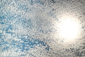 Bright sun shining through textured altocumulus clouds