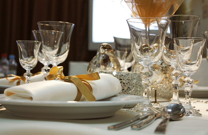 Elegant Formal Table Setting With Gold Ribbon Napkin And Crystal Glassware