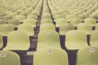 Rows of empty green stadium seats with numbers