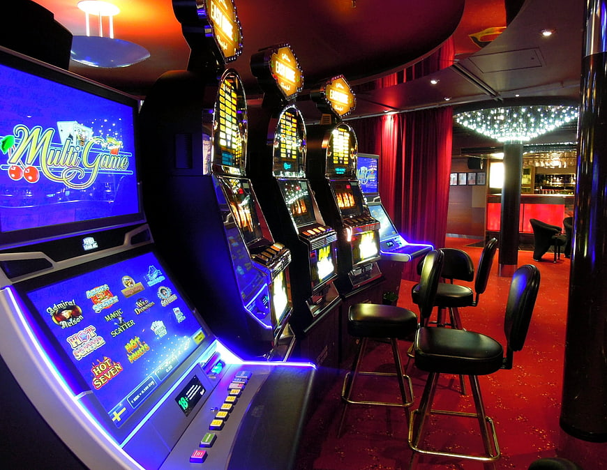 Row of glowing slot machines in a modern casino lounge