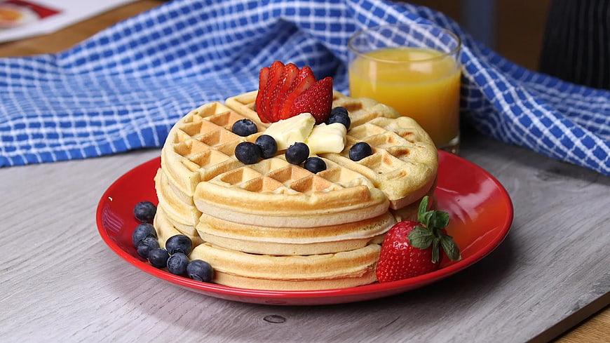 Stack of Waffles with Berries and Butter on Red Plate