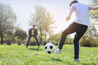 Family Playing Soccer in Sunny Park