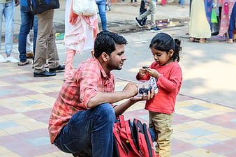 Father feeding daughter berries on colorful tiled street
