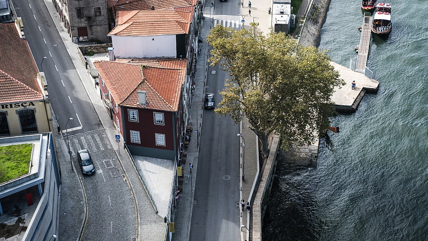 Aerial View of Riverside Street with Red Roofs and Boats